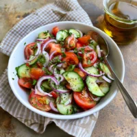 Marinated Cucumber, Tomato, and Onion Salad served in a bowl