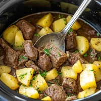 Delicious Slow Cooker Steak and Potatoes served warm with garlic and butter flavor.