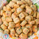 Christmas Shortbread Cookie Bites with festive sprinkles spilling from a red bowl