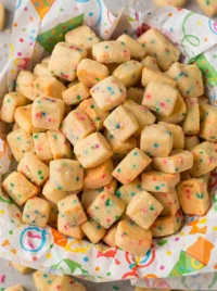 Christmas Shortbread Cookie Bites with festive sprinkles spilling from a red bowl