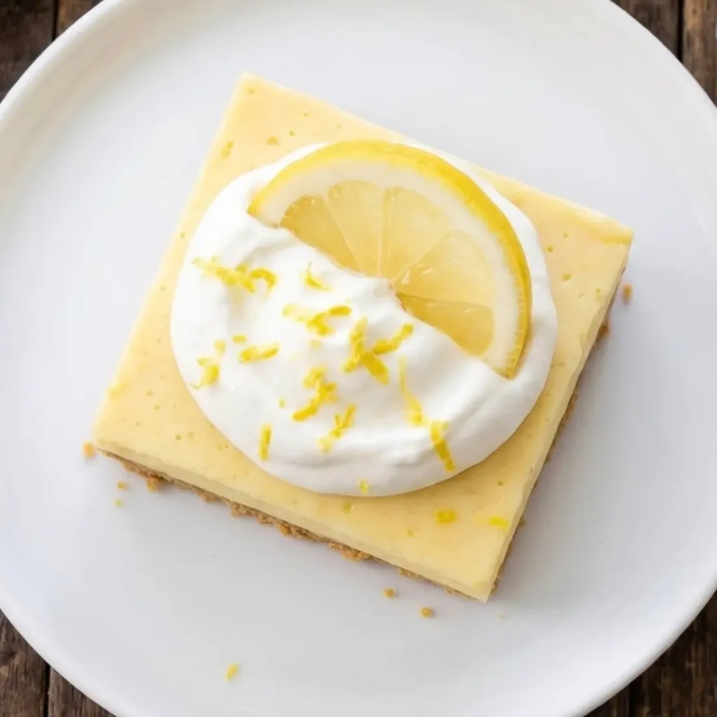 Creamy Lemon Bars on a cooling rack with a buttery crust, smooth lemon filling, and fresh lemon slices